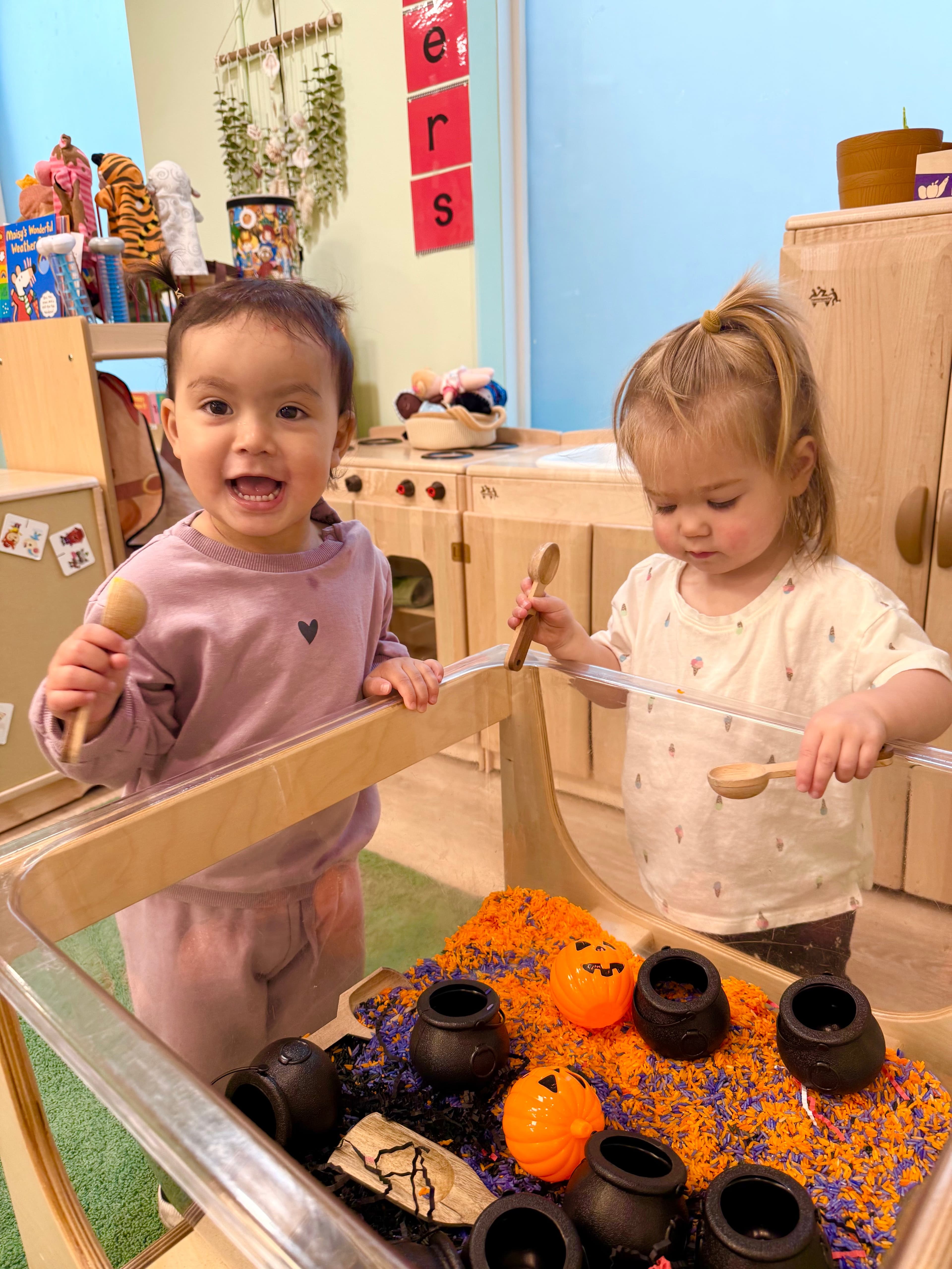 Child sorting colorful fall materials in the classroom