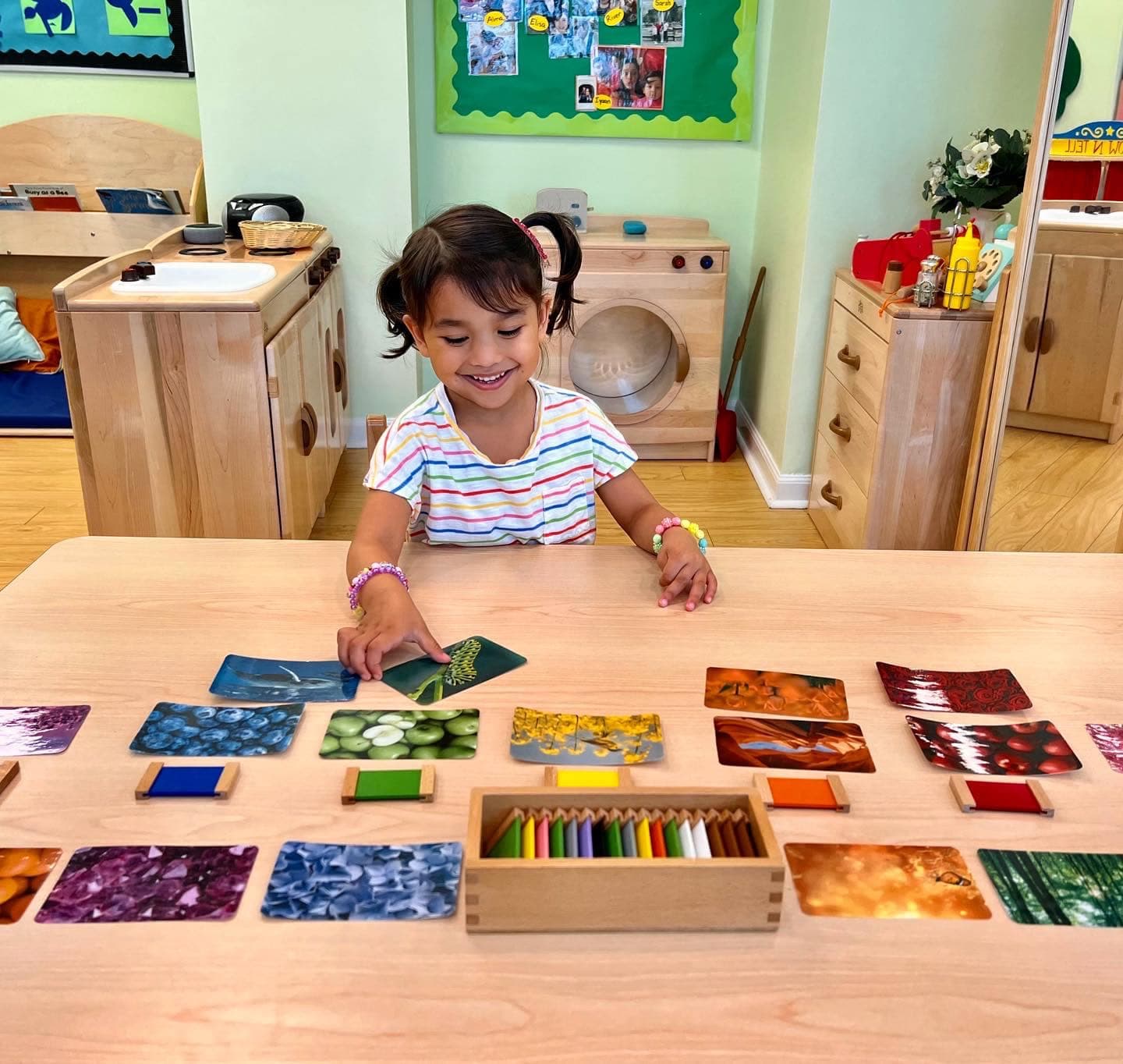 Preschooler matching Montessori color tablets to nature photo cards
